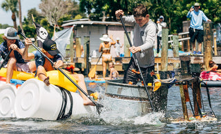 Two homemade paddle crafts built from barrels and a galvanized stock tank race through the squirt gun challenge during Blueline Surf & Paddle Co.'s Whatever Floats Your Boat event in Jupiter, Florida.