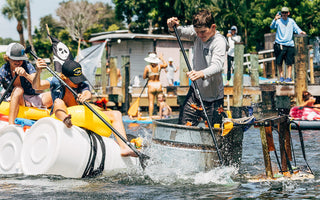 Two homemade paddle crafts built from barrels and a galvanized stock tank race through the squirt gun challenge during Blueline Surf & Paddle Co.'s Whatever Floats Your Boat event in Jupiter, Florida.