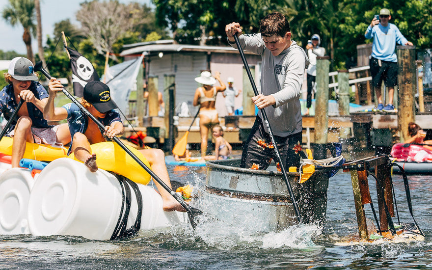 Two homemade paddle crafts built from barrels and a galvanized stock tank race through the squirt gun challenge during Blueline Surf & Paddle Co.'s Whatever Floats Your Boat event in Jupiter, Florida.