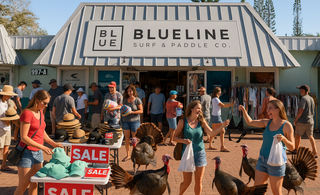 A busy outdoor parking lot Black Friday sale at Blueline Surf & Paddle Co. in Jupiter, Florida, with shoppers browsing racks and tables of clothing while several turkeys wander through the scene on a sunny day.