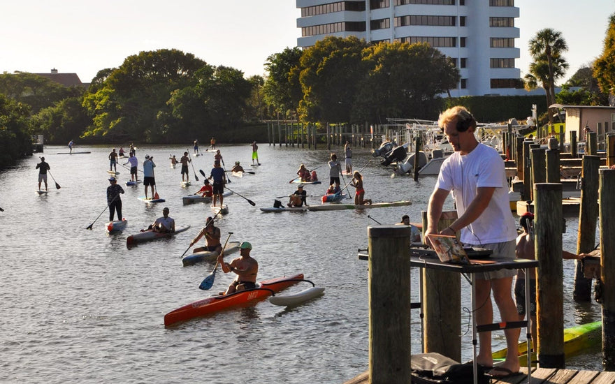 Over 60 paddlers racing paddleboards, surf skis, and outrigger canoes during Tuesday Night Race League at Guanabanas in Jupiter, Florida.