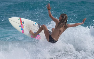 Female surfer riding a wave during the ESA surf contest weekend in Jupiter, Florida.