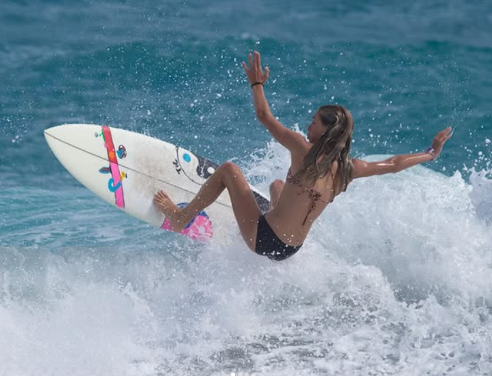 Female surfer riding a wave during the ESA surf contest weekend in Jupiter, Florida.