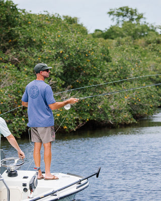 Two men fishing from a boat on the Loxahatchee River in Jupiter, Florida, wearing Blueline Surf & Paddle apparel. Representing the South Florida lifestyle and men’s outdoor collection.