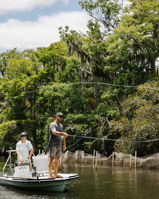 Blueline Surf and Paddle signature rope hat worn by an angler fishing in Jupiter, FL. Performance headwear designed for boating and sun protection.