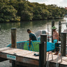 Dock hand preparing stand-up paddleboard rental at the Blueline Surf & Paddle Co. floating dock at Guanabanas in Jupiter, Florida, for the Tuesday Night Race League.