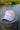 Blueline Kids Surfboard Tech Hat in Lavender and White displayed on a dock in Jupiter, Florida.