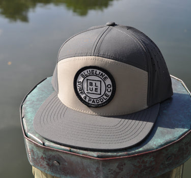 Blueline Logo Hat in Gravel and Basal with flat bill and patch on dock in Jupiter Florida