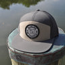 Blueline Logo Hat in Gravel and Basal with flat bill and patch on dock in Jupiter Florida