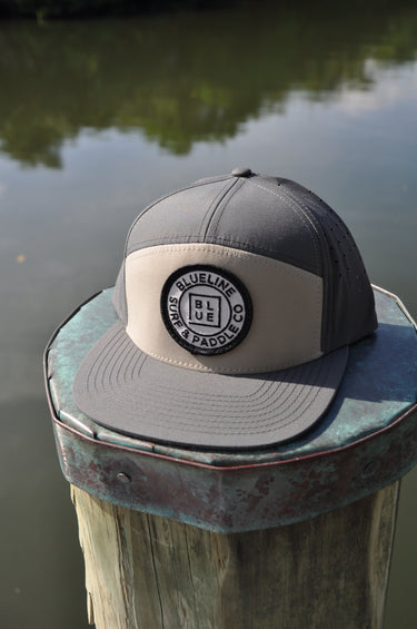 Blueline Logo Hat in Gravel and Basal with flat bill and patch on dock in Jupiter Florida