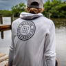 Man wearing a white and gray Blueline OG Circle UV sun hoodie standing on a dock in Jupiter, Florida.