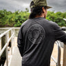 Man wearing a charcoal heather Blueline OG Circle long sleeve UV sun shirt standing on a dock in Jupiter, Florida.