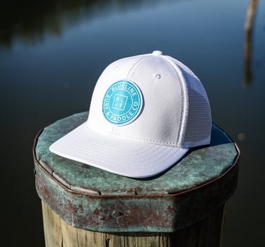 OG Blueline Logo UV Lite Hat in white with aqua patch on dock