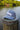 Blueline Kids Surfboard Tech Hat in slate and White displayed on a dock in Jupiter, Florida.