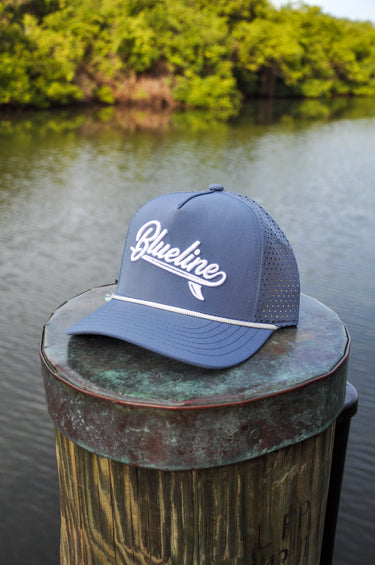 Blueline Kids Surfboard Tech Hat in slate and White displayed on a dock in Jupiter, Florida.