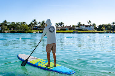Paddleboarder wearing a Blueline hooded UV sun shirt on the Intracoastal Waterway in Jupiter, Florida