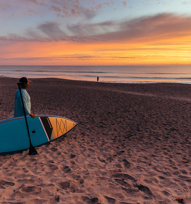 Small waves are an invitation for a paddleboarder in Jupiter Florida during sunrise. 