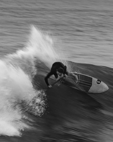 Surfer on the face of a wave on the Starboard Twin Fin in Acute Carbon