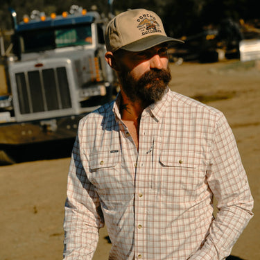 Man wearing Poncho Long Nose Pete plaid button-down shirt outdoors