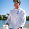 Man wearing the ANETIK x Blueline Vintage Circle Men’s UV Tech Hoody in White and Navy while boating in Jupiter, Florida