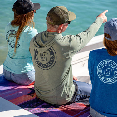 ANETIK x Blueline Vintage Logo Low Pro UV Hoodie – Olive, shown with other ANETIK x Blueline sun shirts on a boat in Jupiter, Florida