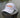 The Blueline America 250 performance hat in white featuring a clean, rope-free front profile, displayed on a weathered wood piling along the water in Jupiter, Florida.