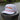 The Blueline America 250 performance rope hat in white from the Americana Edit collection, displayed on a wooden dock piling along the Intracoastal water in Jupiter, Florida.