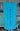 Blueline Beach Towel in turquoise featuring the vertical Blueline logo displayed outside Blueline Surf & Paddle Co. in Jupiter, Florida.