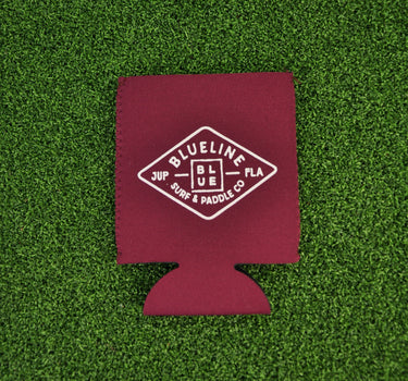 Maroon neoprene Blueline diamond logo koozie with white print displayed on grass