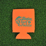 Orange neoprene Blueline jumping mahi logo koozie with aqua print displayed on grass