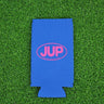 Royal blue neoprene Blueline JUP slim can koozie with pink logo displayed on grass