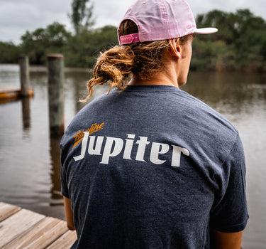 Man at Blueline Surf and Paddle dock wearing a Blueline Jupiter T-shirt in heather navy.
