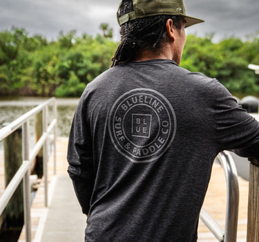 Blueline OG Circle UV Long Sleeve Sun Shirt – Charcoal Heather, worn on a dock in Jupiter, Florida