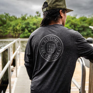Blueline OG Circle UV Long Sleeve Sun Shirt – Charcoal Heather, worn on a dock in Jupiter, Florida