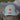 Blueline OG Leather Patch Trucker Hat in Smoke Blue featuring a genuine etched leather Blueline patch and breathable mesh back, displayed outdoors in Jupiter, Florida.