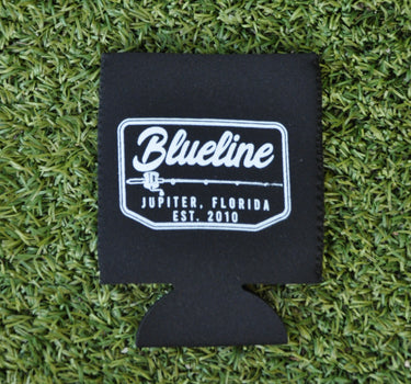 Black neoprene Blueline Rod & Reel logo koozie with white print displayed on grass