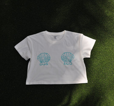 Front and back view of the Blueline Shell Crop Tee in natural featuring a left chest logo and large shell graphic on the back.
