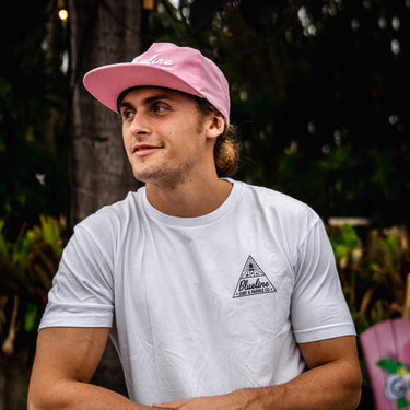Man wearing a washed white Blueline Triangle Lighthouse T-shirt with small front chest logo, photographed outdoors in Jupiter, Florida.