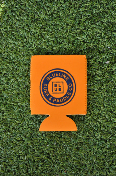 Orange neoprene Blueline Vintage Circle logo koozie displayed on grass
