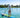 Man paddleboarding on clear blue water wearing a light blue Blueline Vintage Circle Low Pro UV sun hoody.