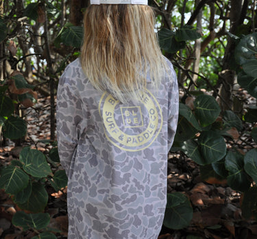 Child wearing the Blueline Vintage Youth Hooded UV Sun Shirt in Duck Camo while exploring the Florida coastline.