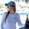 Woman wearing a white Blueline long-sleeve UV sun shirt by the water in Jupiter, Florida.