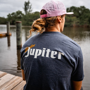Man at Blueline Surf and Paddle dock wearing a Blueline Jupiter T-shirt in heather navy.