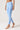 A model wearing light blue high-waisted leggings with a side cutout near the ankle.