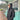 Man wearing ID Simmons black hooded puffy jacket outside surf shop