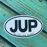 JUP Blueline Surf and Paddle Co. 5-inch sticker featuring bold black JUP logo and Blueline Surf text, on a white oval inside a black circle. The JUP Sticker. 