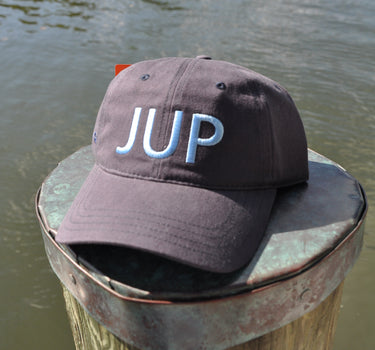 JUP Cotton Twill Hat Navy/Carolina with bold JUP lettering on dock in Jupiter Florida
