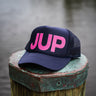 JUP Pink Logo Hat by Blueline Surf & Paddle Co. in Jupiter, Florida, featuring bold pink JUP letters on navy mesh snapback hat.