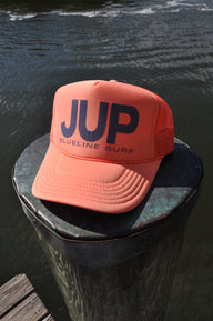 JUP coral trucker hat on dock by the water in Jupiter Florida