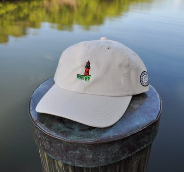Putty colored Jupiter Lighthouse Strapback Hat from Blueline Surf & Paddle Co. featuring embroidered lighthouse artwork and relaxed coastal styling inspired by the Jupiter Florida lifestyle.